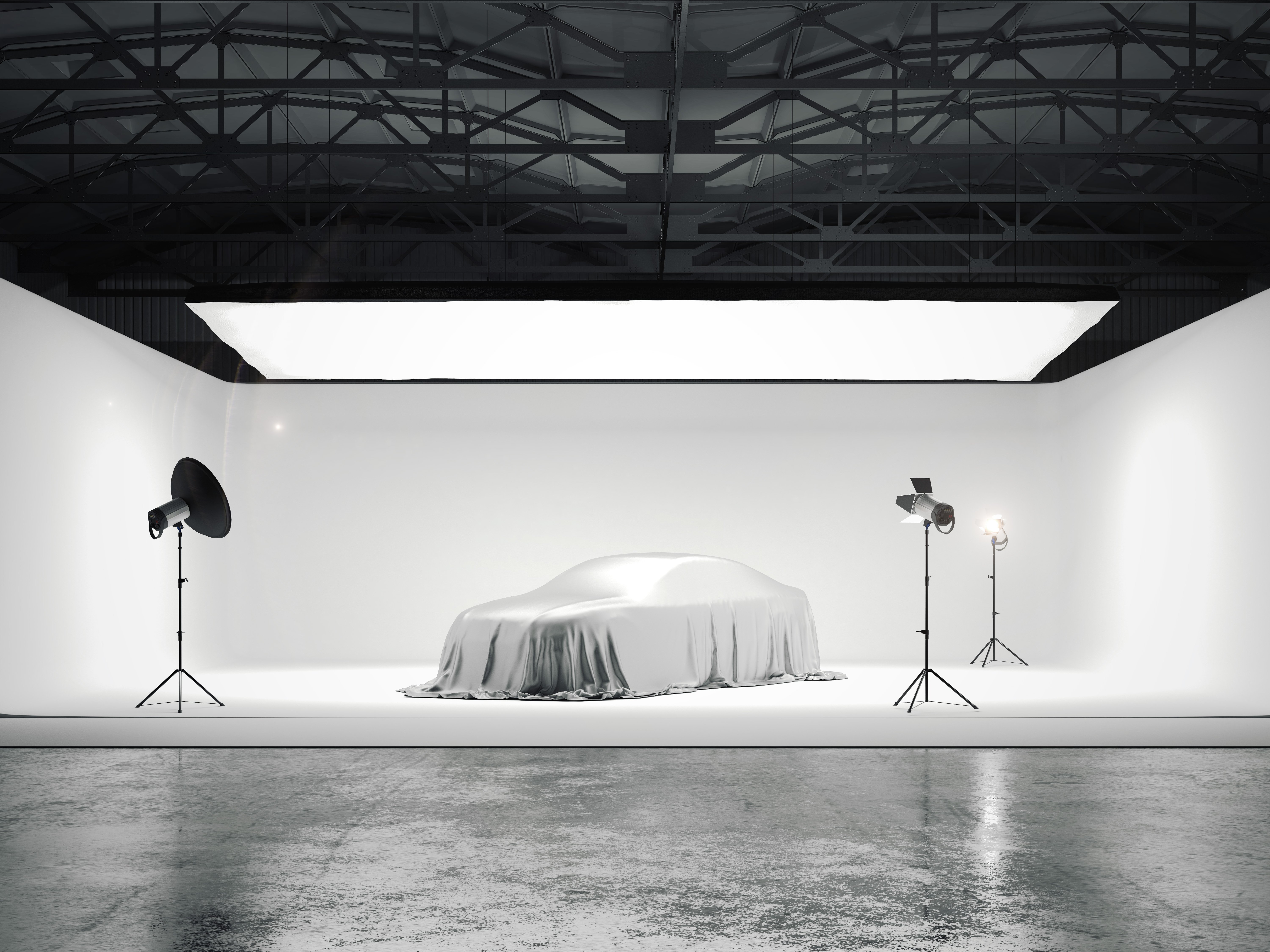 Large photographic studio with a car and several light sources
